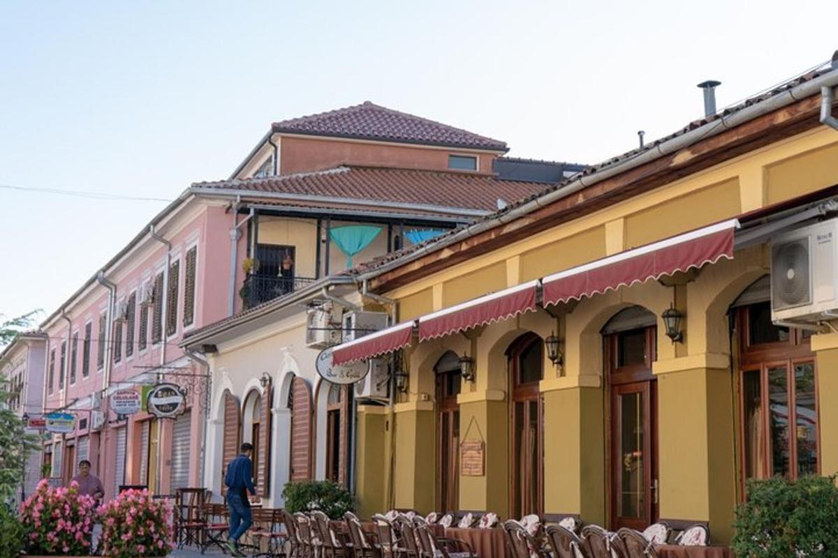 a man walking down a street next to buildings
