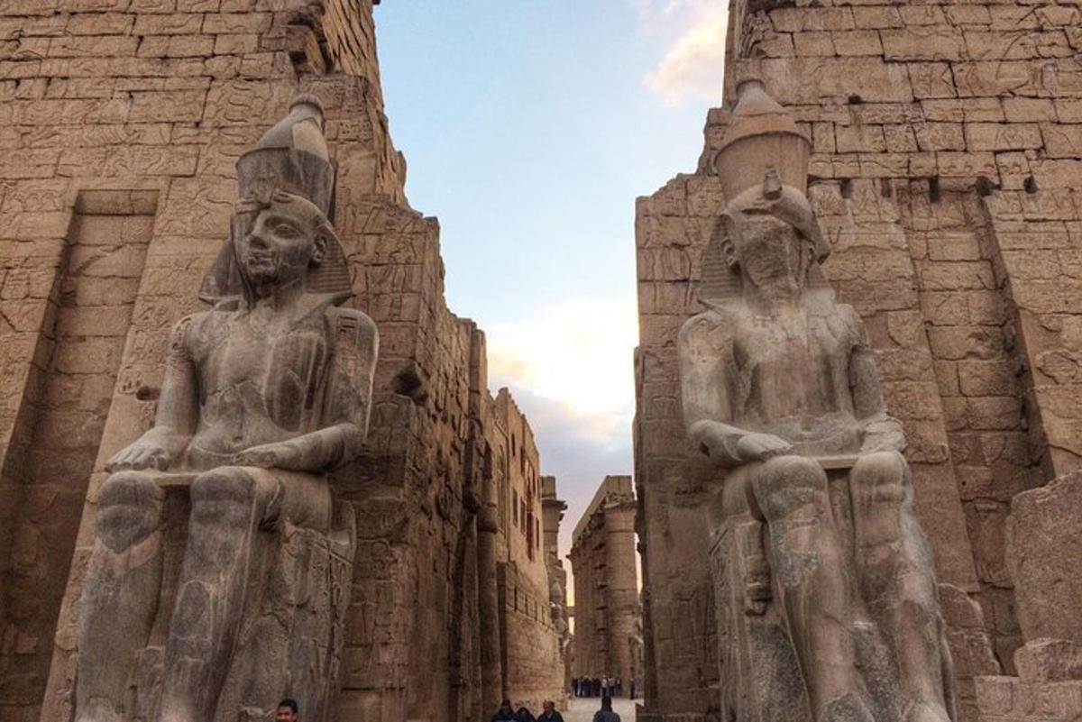 Dos estatuas de personas de pie junto a un edificio.