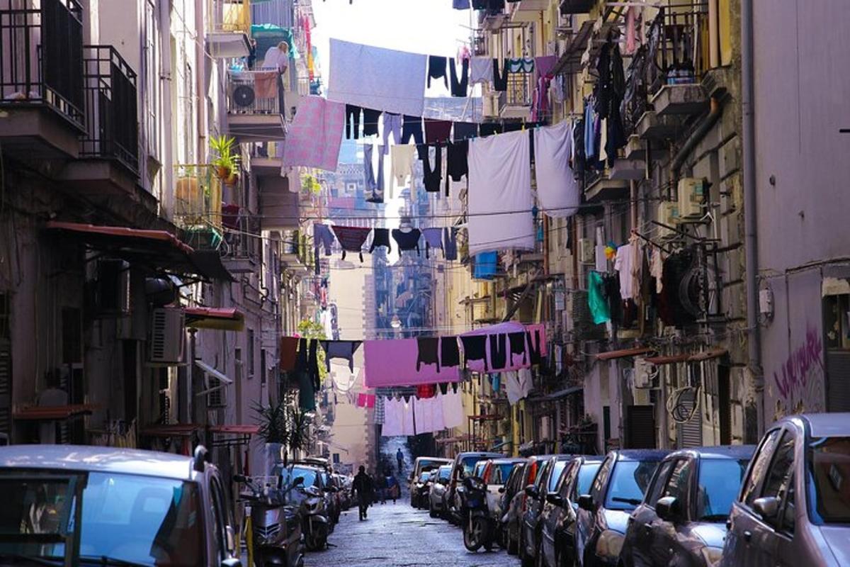 mestna ulica z vrvmi za perilo in avtomobili, parkiranimi na ulici