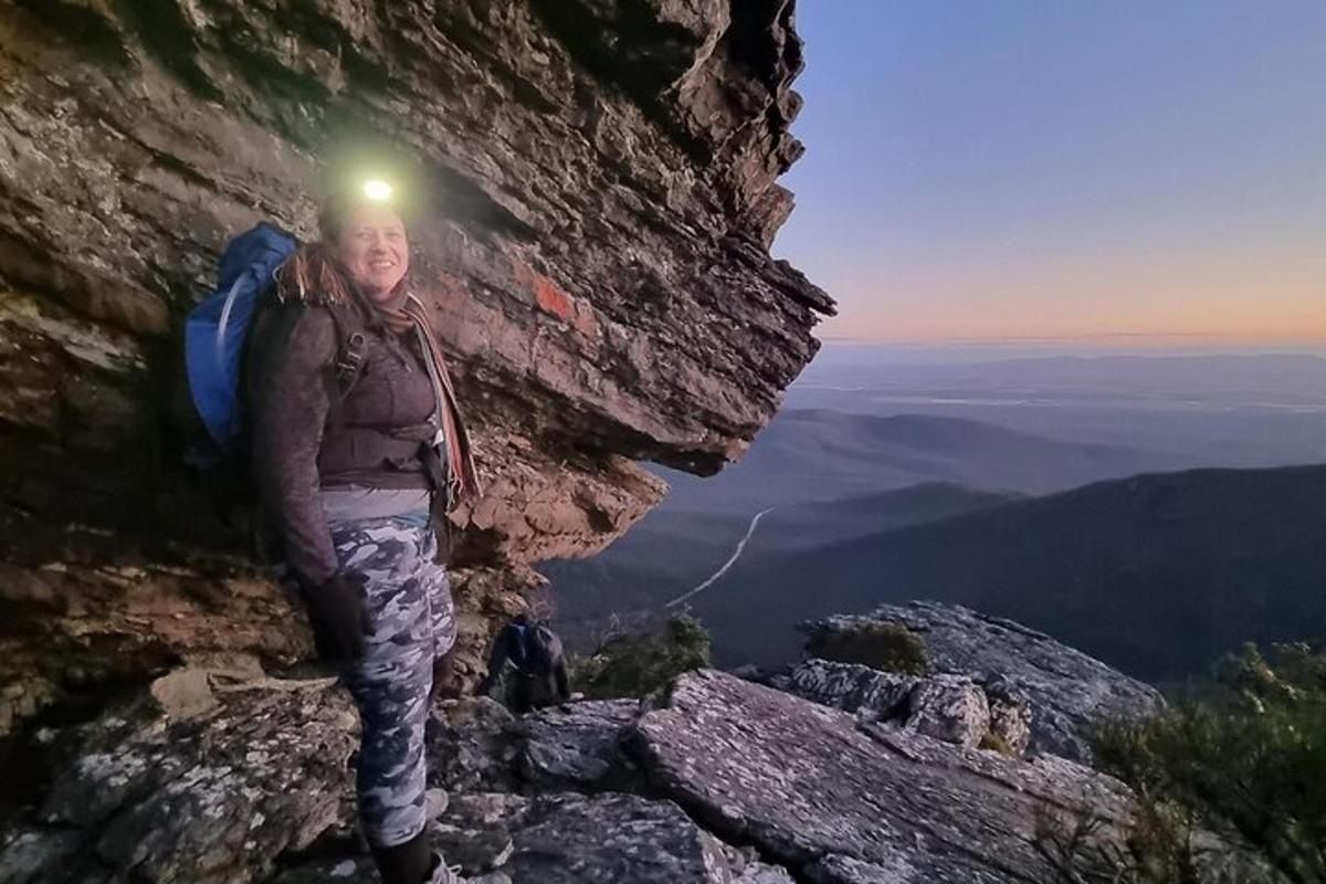 una mujer parada en la ladera de una montaña