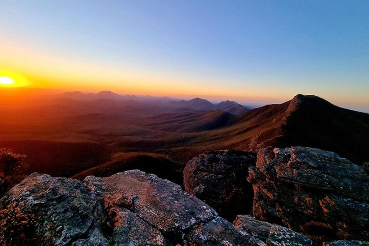 Una vista de una puesta de sol desde la cima de una montaña