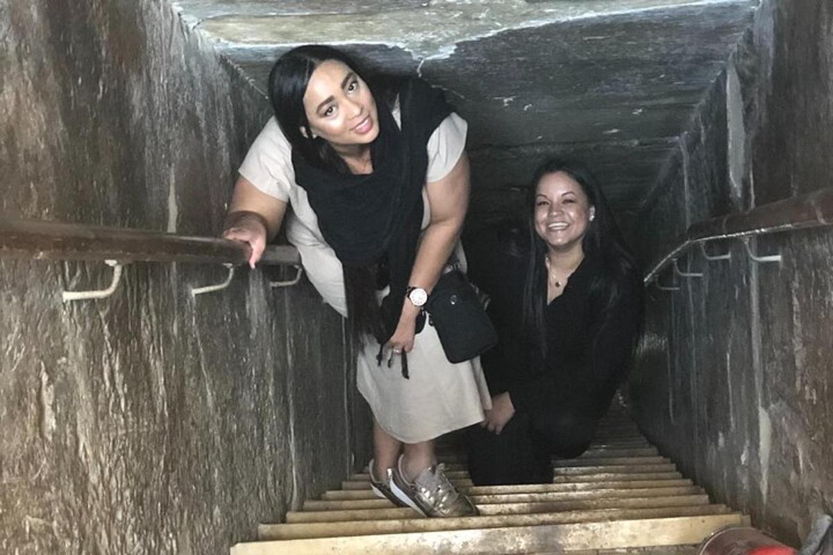 Dos mujeres están de pie en las escaleras de un túnel.