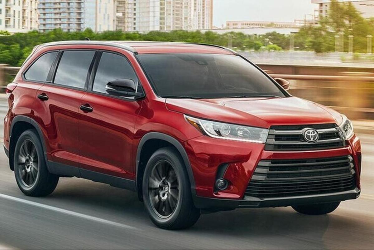 punane Toyota sõidab mööda tänavat
