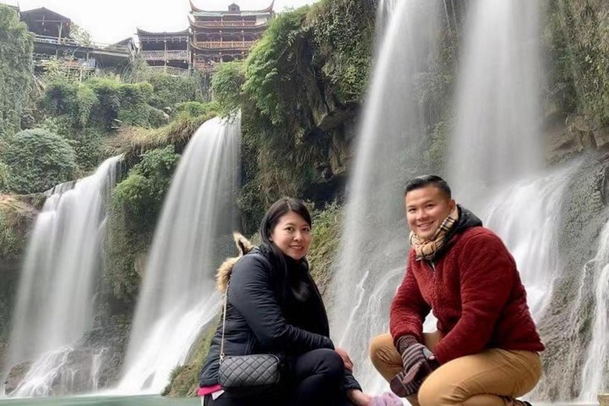 two people sitting in front of a waterfall