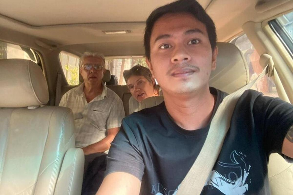seorang pria duduk di kursi belakang mobil