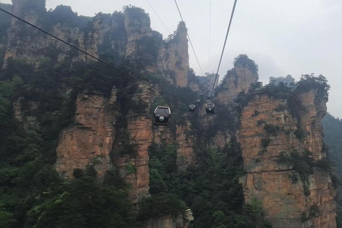 two gondolas on a cable car above the mountains