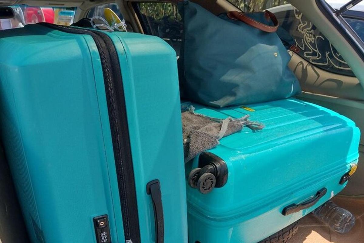 dua buah koper yang diletakkan di bagian belakang mobil