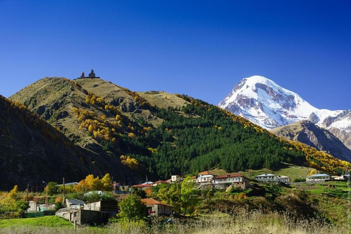un villaggio di fronte a una montagna innevata