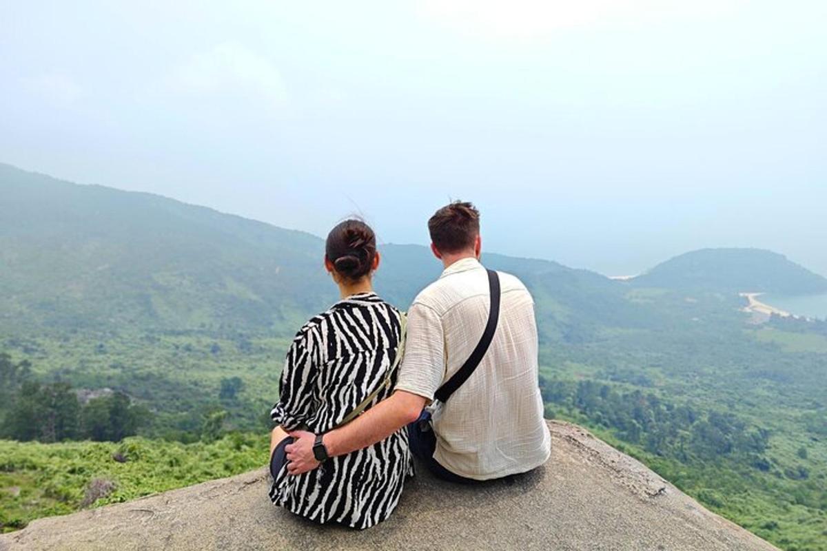 Un hombre y una mujer sentados en la cima de una montaña