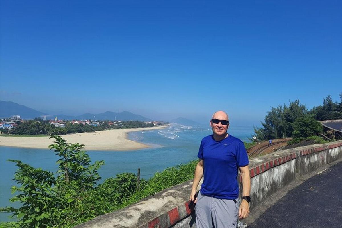 ผู้ชายยืนอยู่บนกำแพงข้างชายหาด