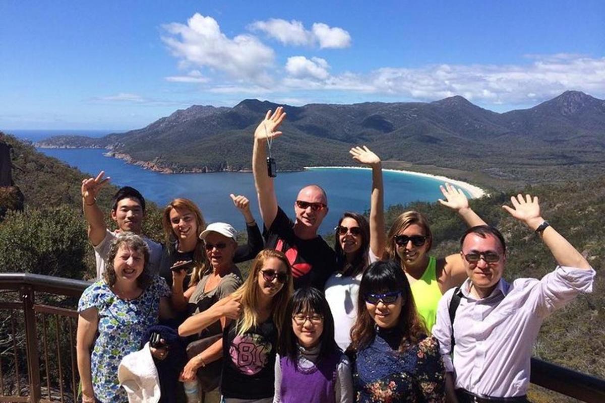 a group of people posing for a picture in front of a lake