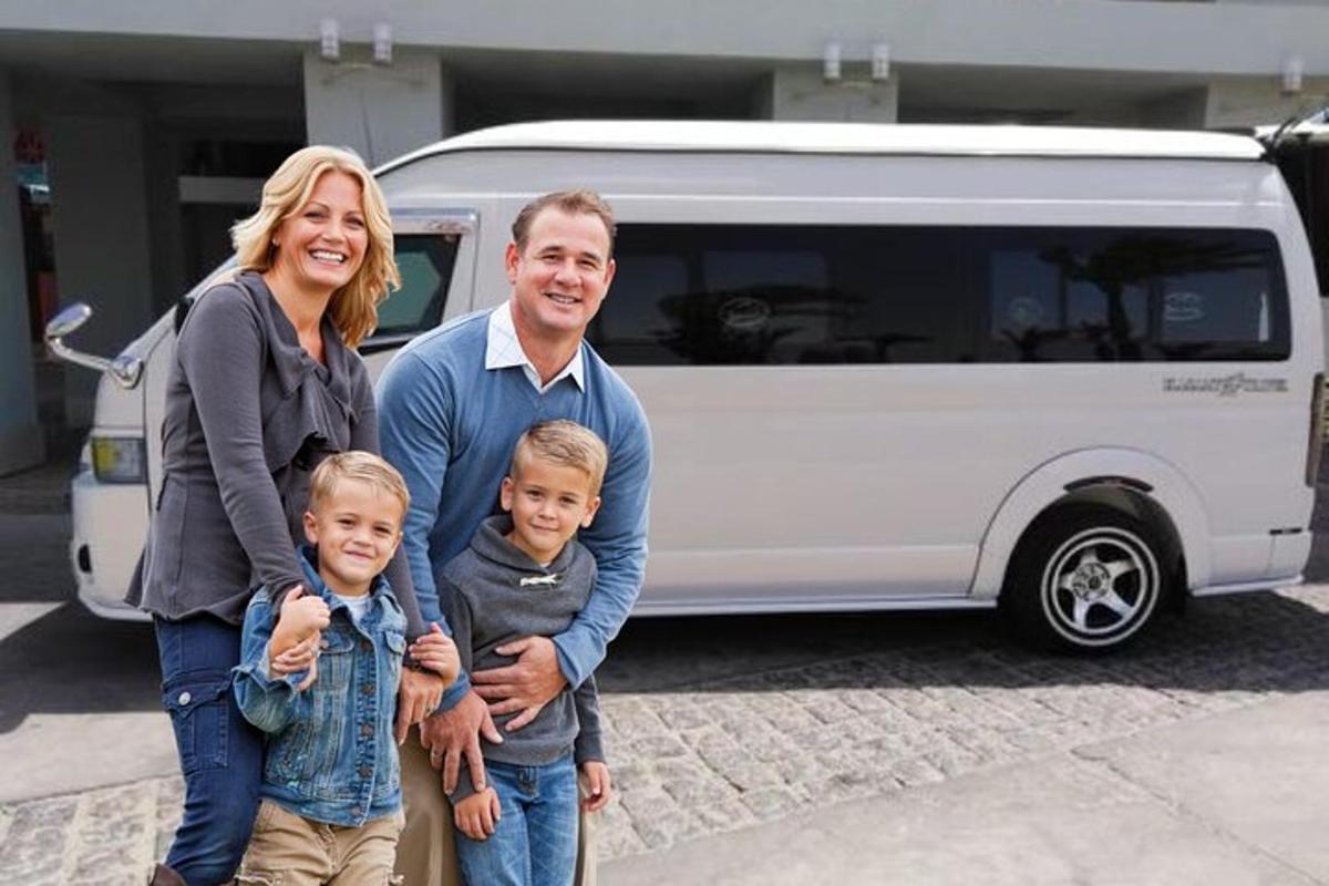 beyaz bir minibüsün önünde duran bir aile