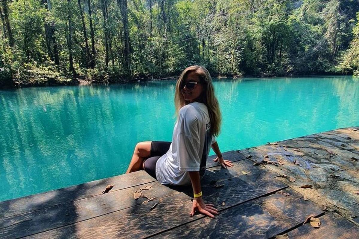 a woman sitting on a dock near a lake