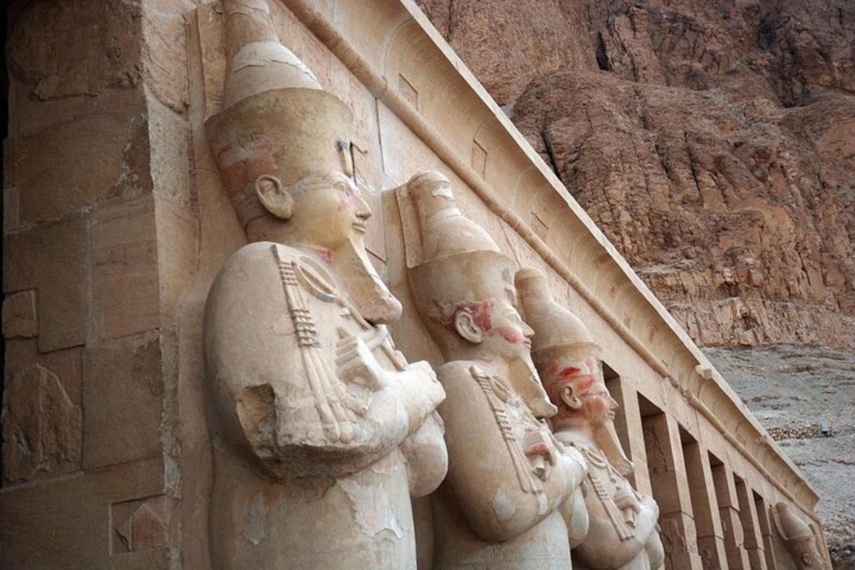 una statua di pietra di persone sul lato di un edificio