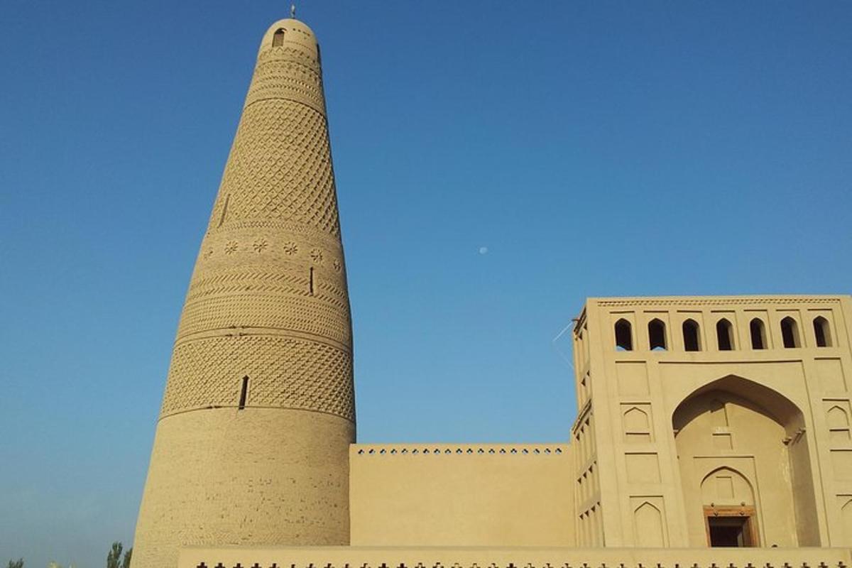 a tall tower next to a building with a blue sky