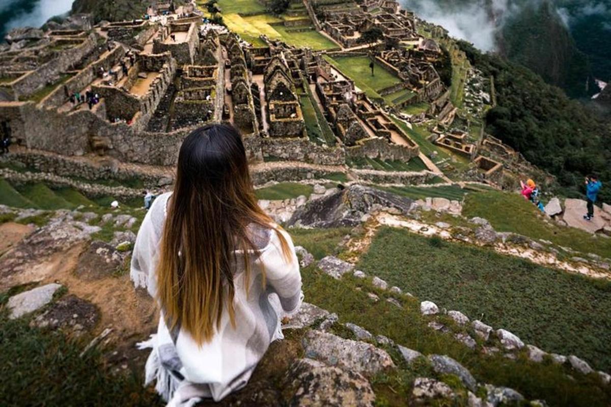 Μια γυναίκα που κάθεται στην κορυφή ενός βουνού κοιτάζοντας τα ερείπια