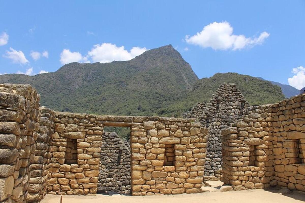 un edifici de pedra amb una muntanya al fons