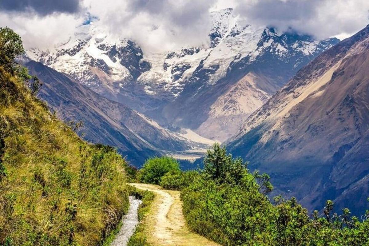 una strada di montagna tortuosa con montagne innevate sullo sfondo