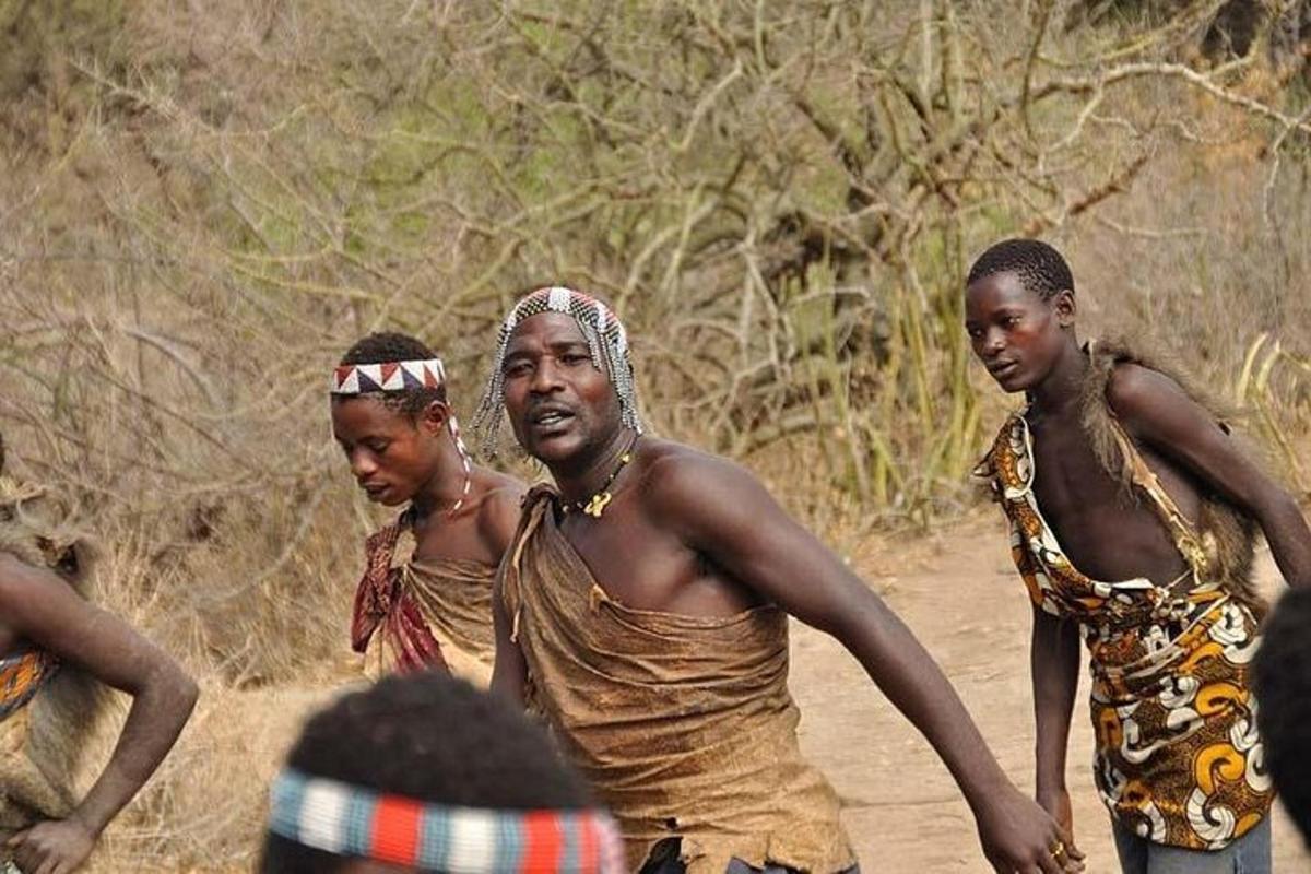 a group of people walking down a dirt road