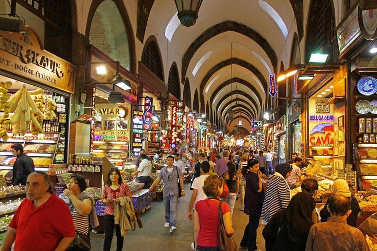una folla di persone che camminano in un mercato con negozi