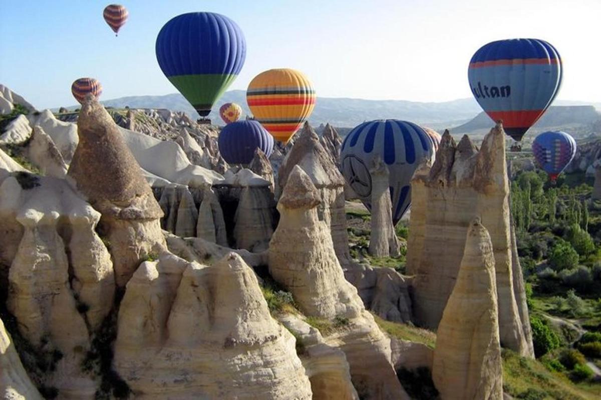 un munt de globus aerostàtics volant sobre unes roques