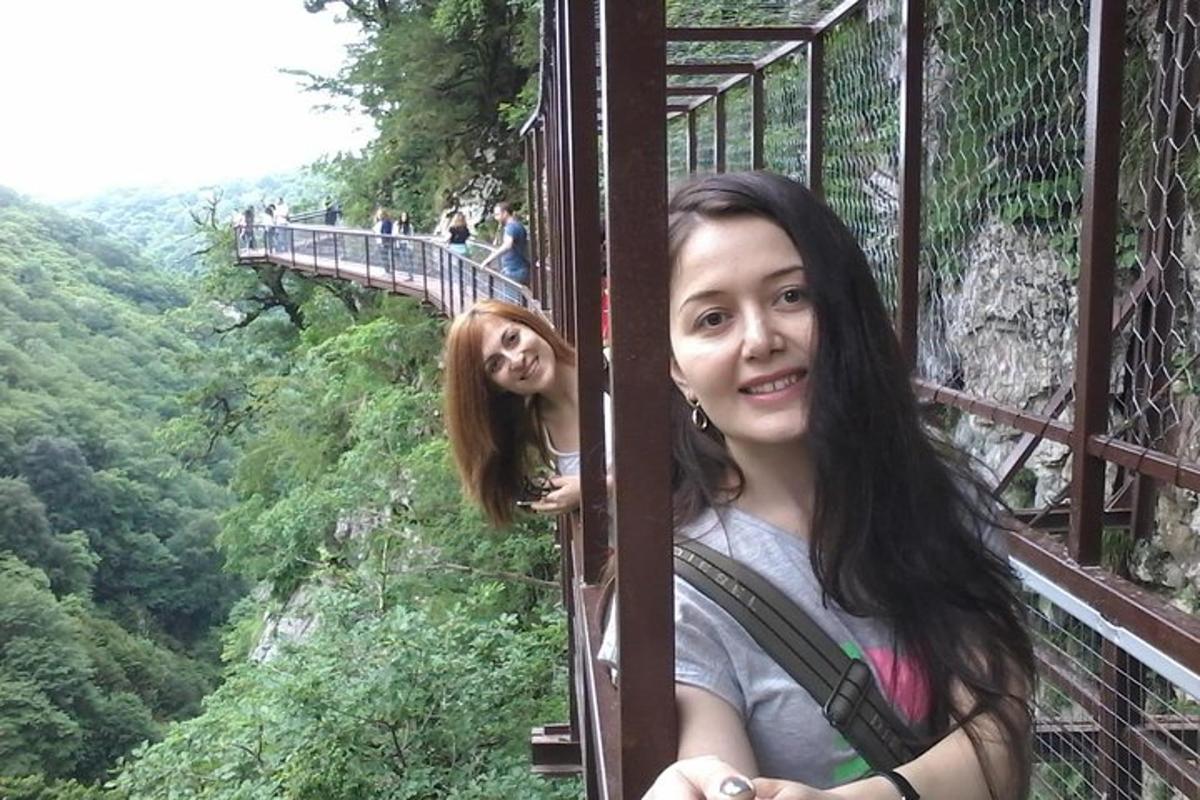 một người phụ nữ đứng trên cầu treo bắc qua một ngọn núi