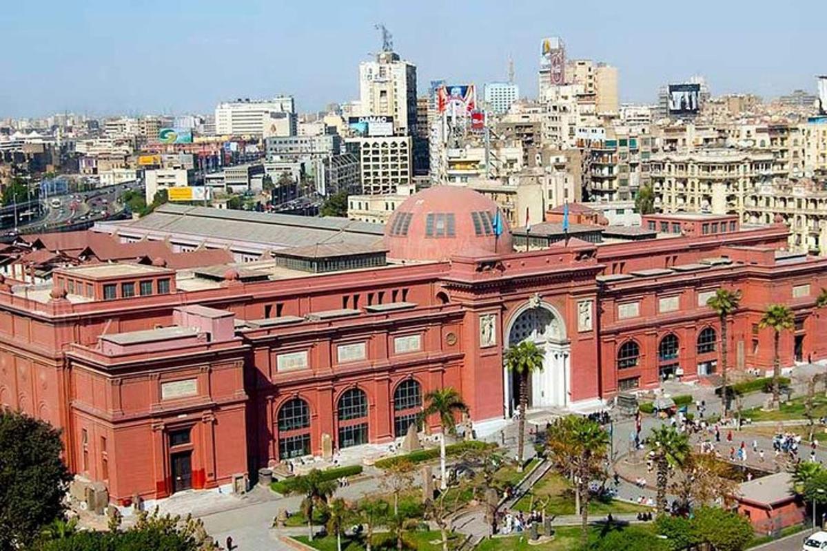 ένα μεγάλο κτίριο από κόκκινο τούβλο με μια πόλη στο φόντο