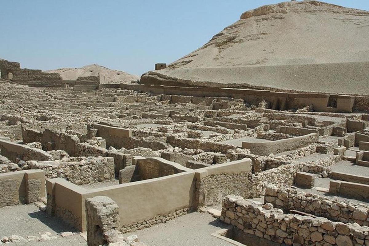 Unas ruinas antiguas con una pirámide al fondo