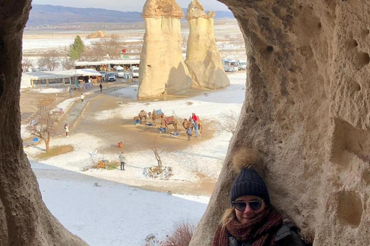 a woman is looking through a hole in a rock