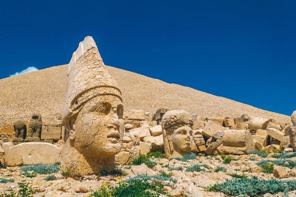 a statue of heads in front of a pyramid
