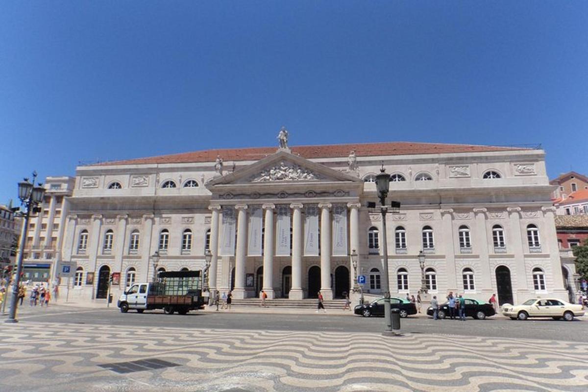 ένα μεγάλο λευκό κτίριο με αυτοκίνητα παρκαρισμένα μπροστά του