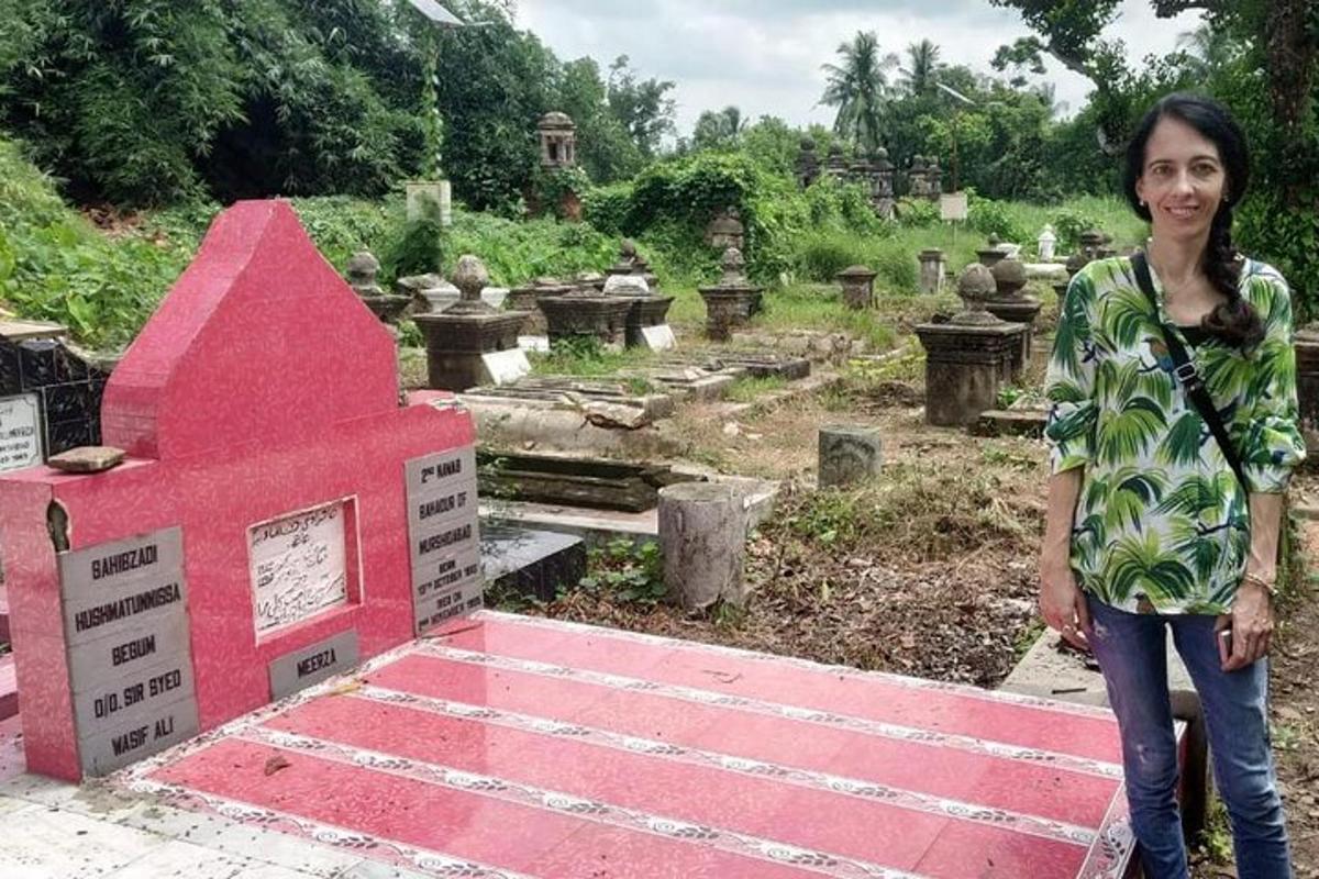a woman standing in front of a cemetery