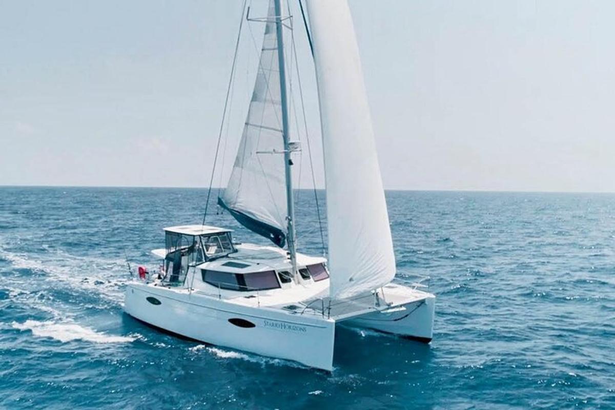 a white sailboat in the ocean on the water