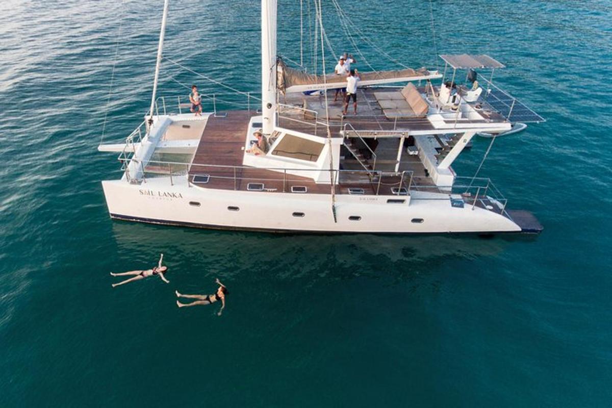 a group of people swimming in the water next to a boat