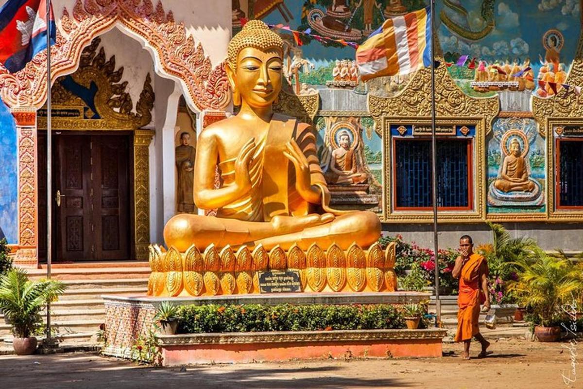 vīrietis stāv lielas zelta statujas priekšā