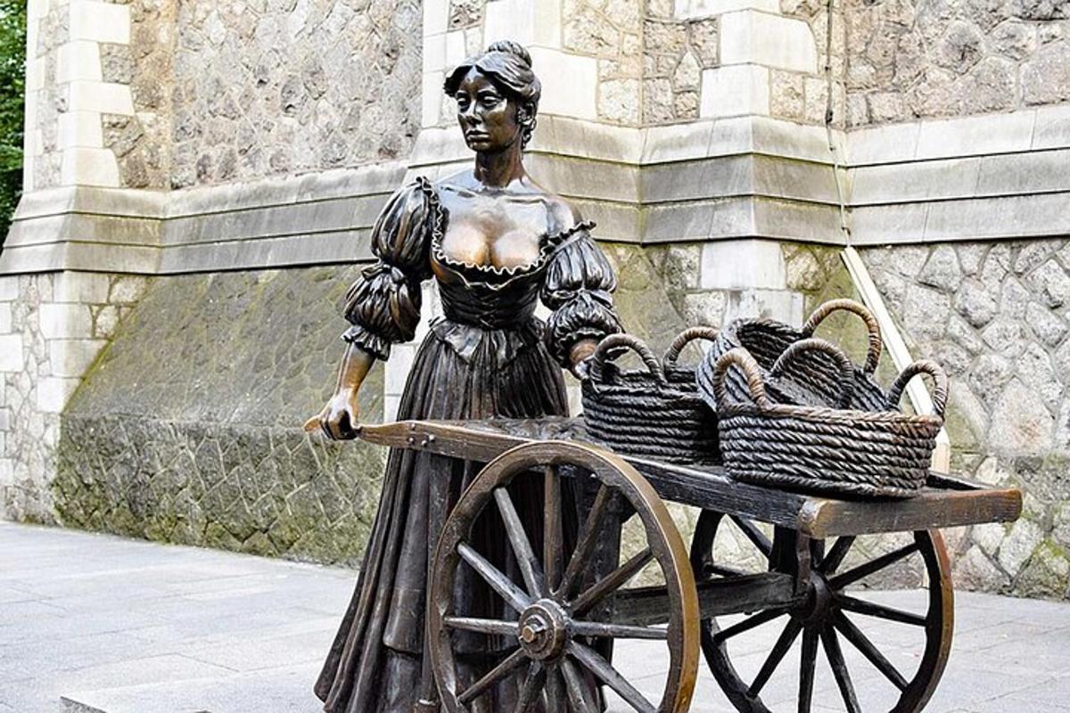 una estatua de una mujer empujando un carro con cestas