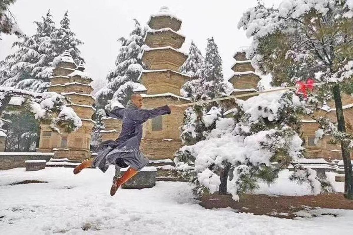a woman playing in the snow with a stick
