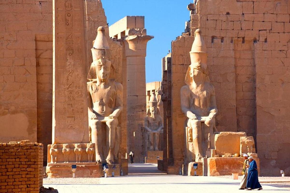 Una mujer caminando frente a un edificio con estatuas.