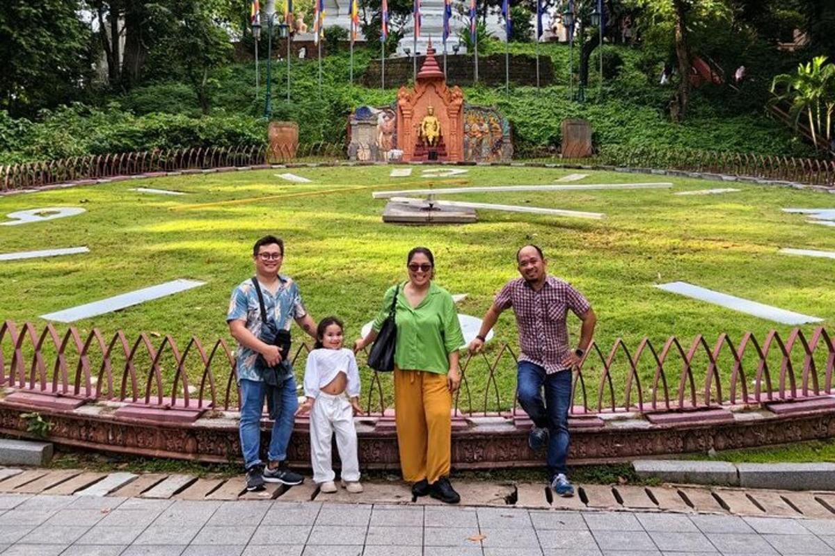 sekeluarga bergambar di hadapan taman