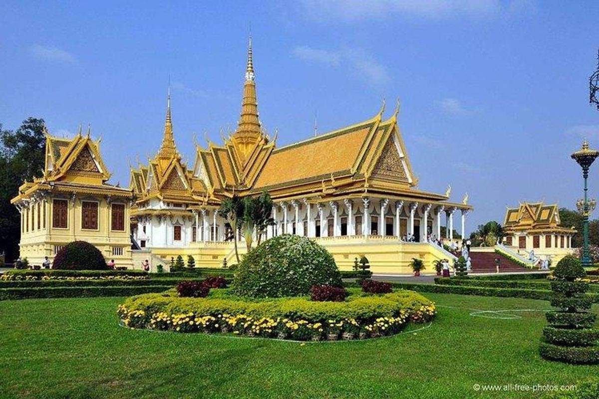 a large yellow building with two towers in a park