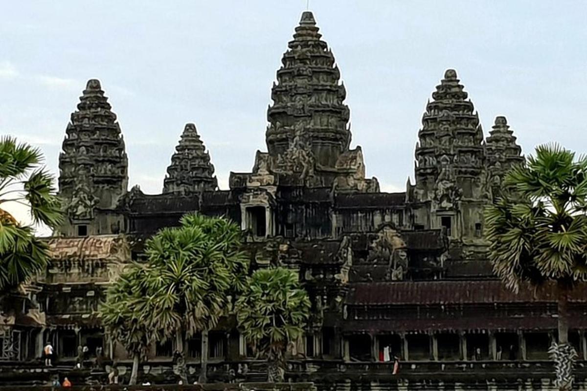 a temple with three towers with palm trees in front