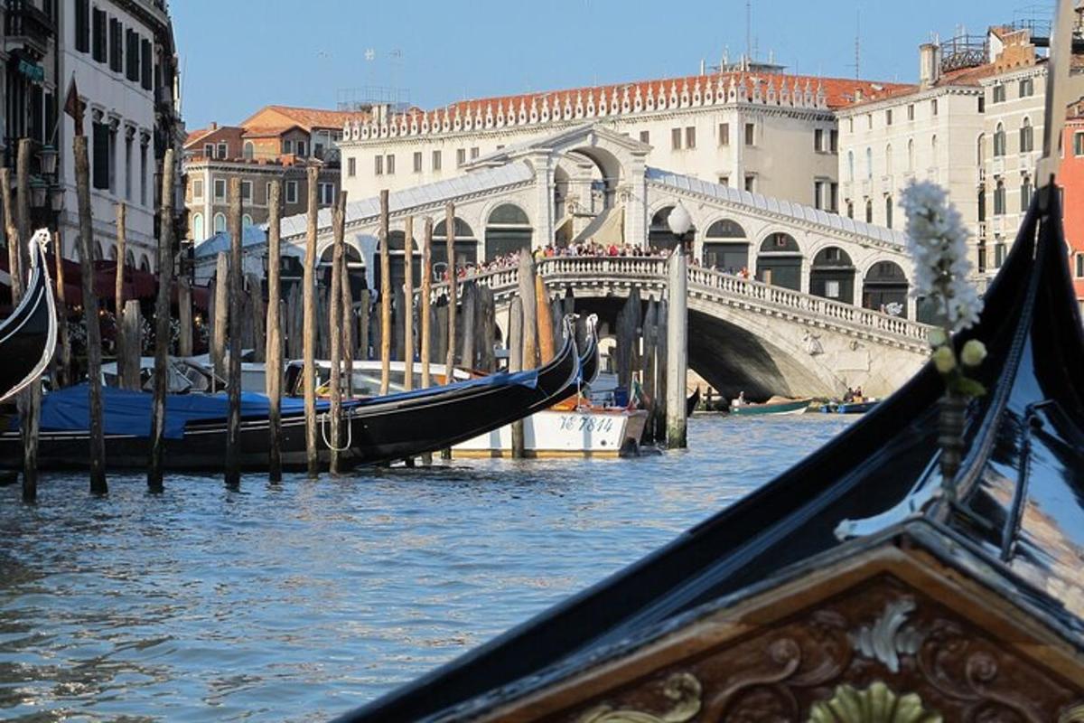 a gondola is docked in a canal with a bridge