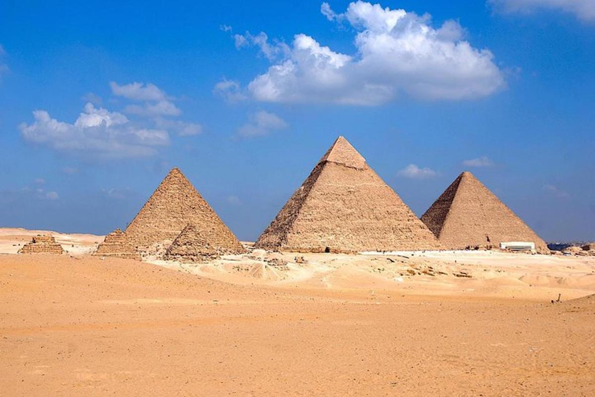 en gruppe pyramider i ørkenen under en blå himmel