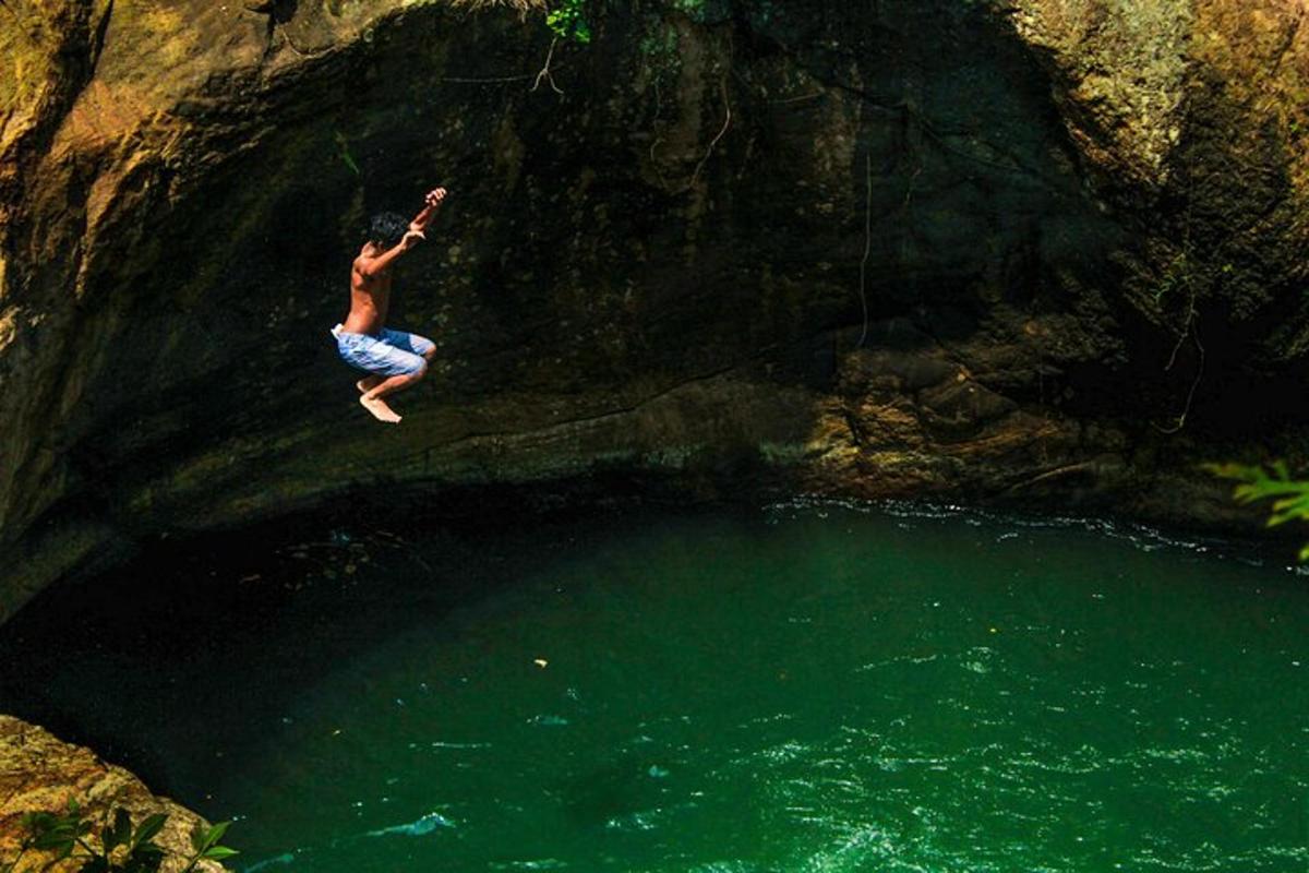 seorang lelaki melompat ke dalam kolam air di dalam sebuah gua
