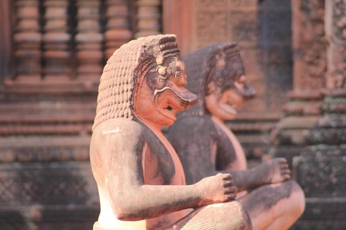 eine Statue von zwei Frauen, die vor einem Gebäude sitzen