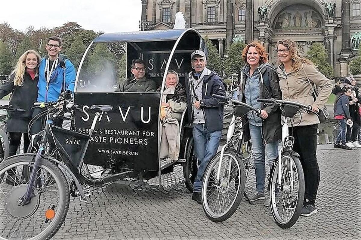 skupina lidí stojící vedle přívěsu za kolo