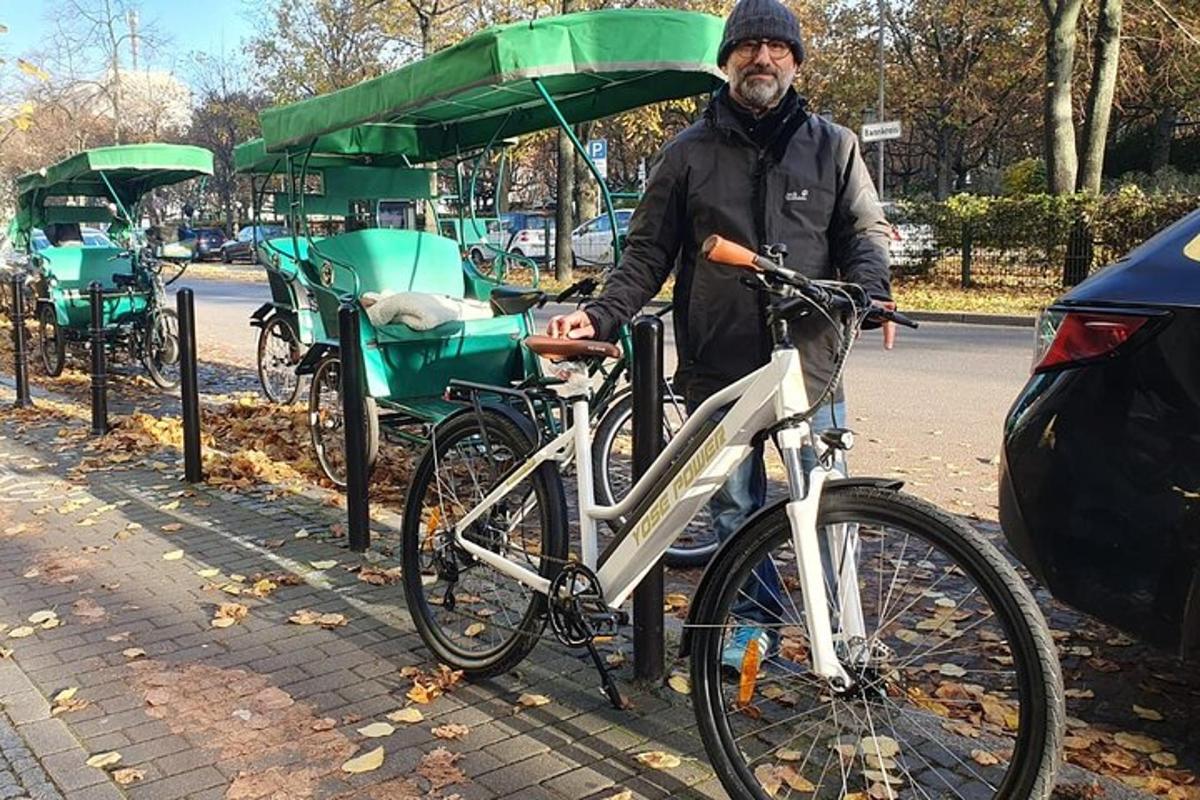 seorang pria berdiri di samping sepeda dengan gerobak