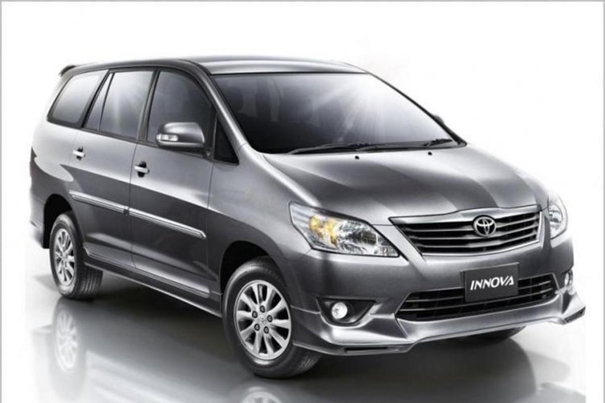 Una minivan Toyota gris sobre un fondo blanco