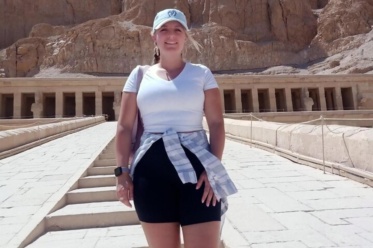 Una mujer con una camisa blanca y una falda en una escalera