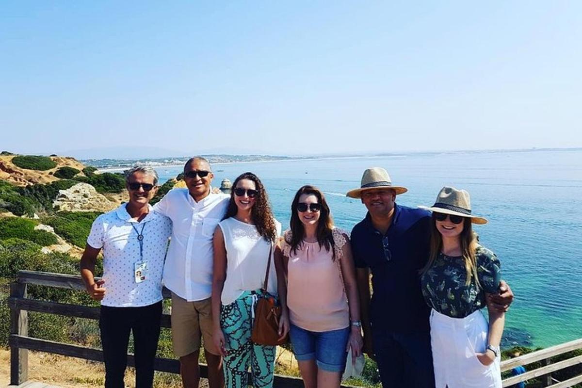 en grupp människor poserar för en bild vid havet